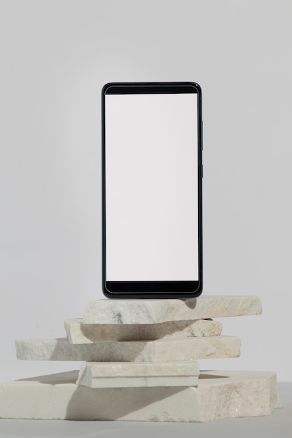 Бесплатное фото Минимальный дисплей смартфона на камнях