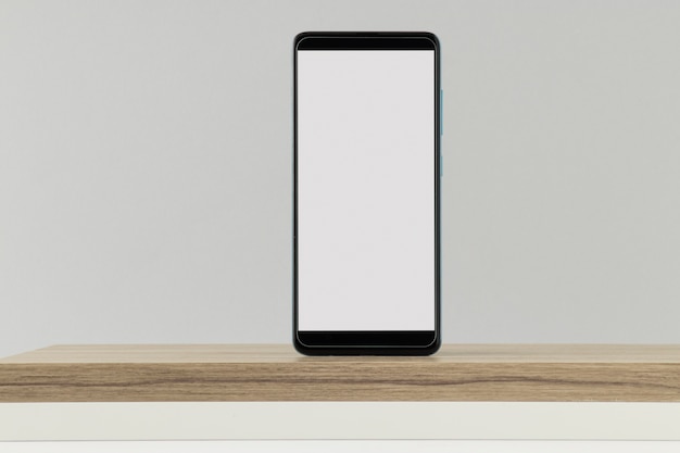 Free photo smartphone minimal display on wooden board