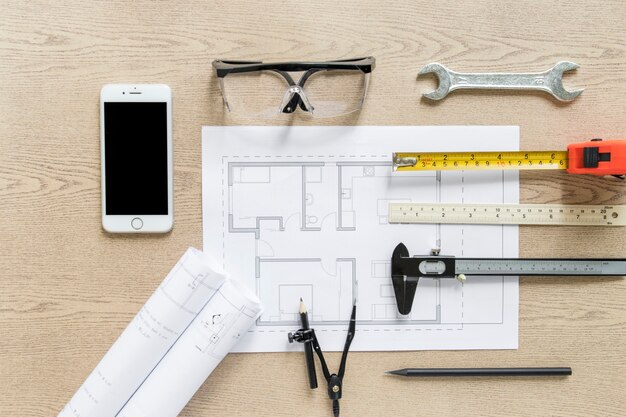 Smartphone near drafts and construction supplies