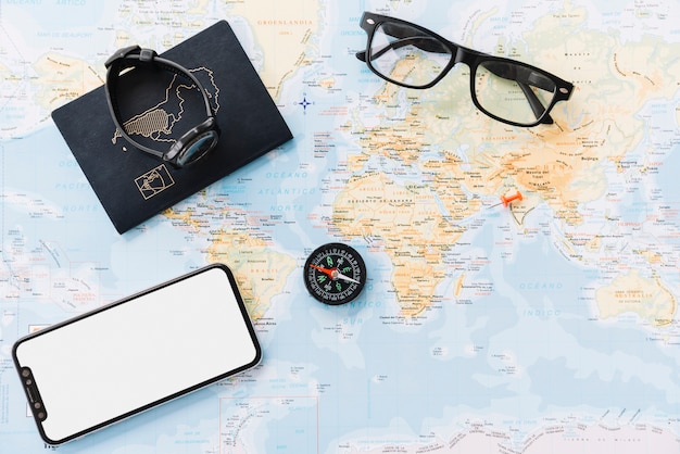 Free photo smartphone; passport; wrist watch; compass and eyeglasses on world map