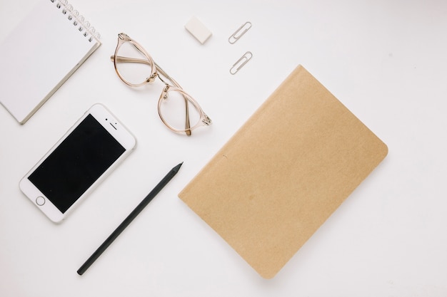 Smartphone and stationery on white