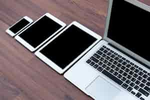 Free photo smartphone, tablets and laptop on a wooden table