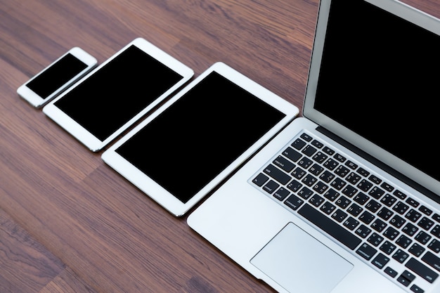 Smartphone, tablets and laptop on a wooden table