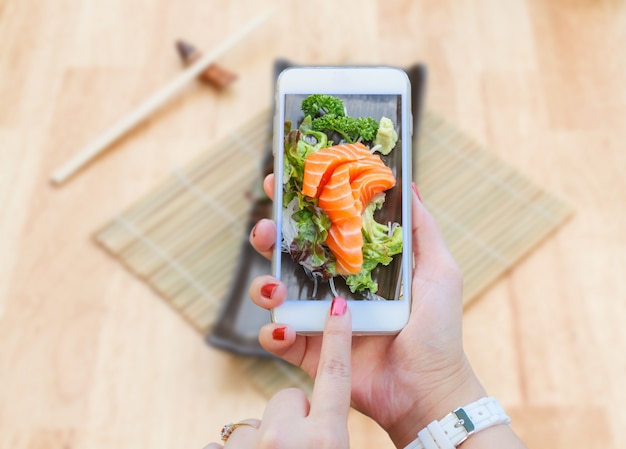 Smartphone taking Sashimi salmon