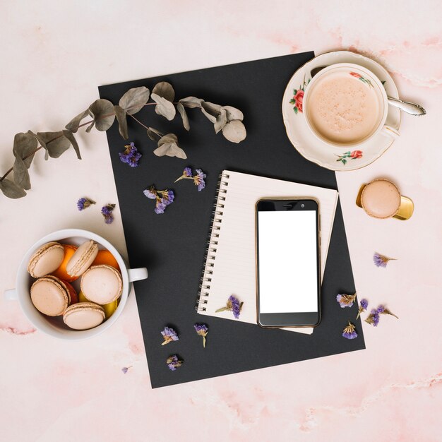 Smartphone with cookies and coffee cup on table