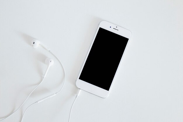 Смартфон с наушниками, изолированных на белом фоне