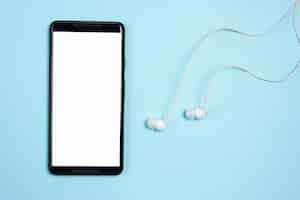 Free photo smartphone with earphones on blue background