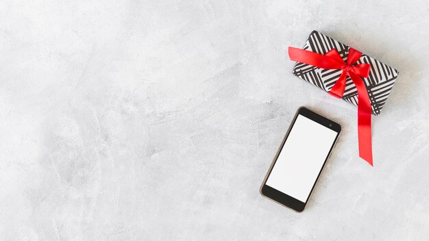 Smartphone with gift box on table 