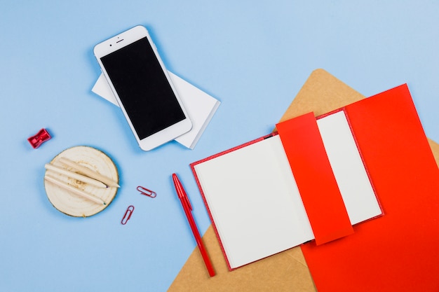 Smartphone with notebook and pencils