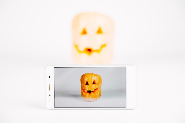 Foto gratuita smartphone con zucca sullo schermo