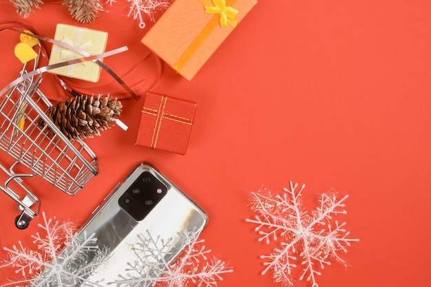 Смартфон с тремя камерами и рождественским декором на красном фоне