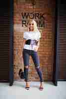 Free photo smile happy blond girl near old bricks wall