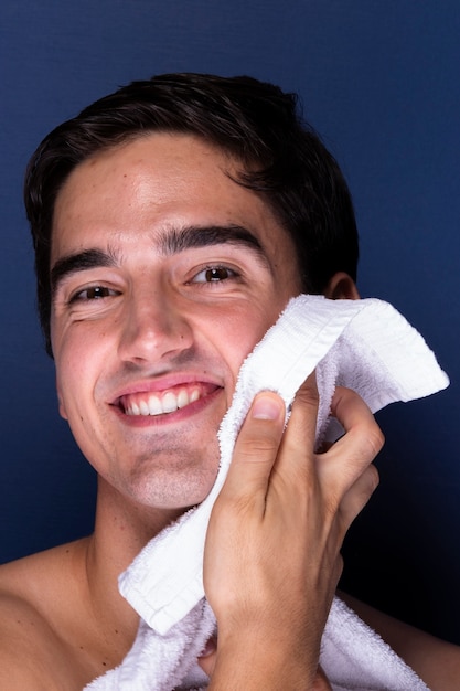 Smiley adult male cleanses face