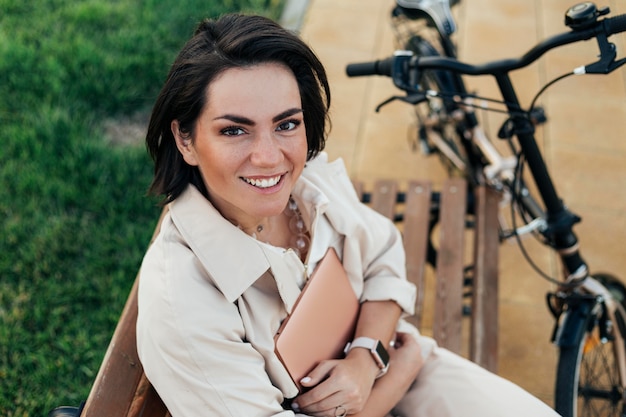 Foto gratuita donna adulta di smiley che posa con la bici