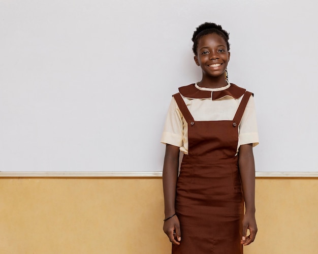 Бесплатное фото Смайлик африканская девушка, стоящая в классе
