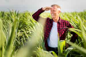 Free photo smiley agronomist looking away in a cornfield