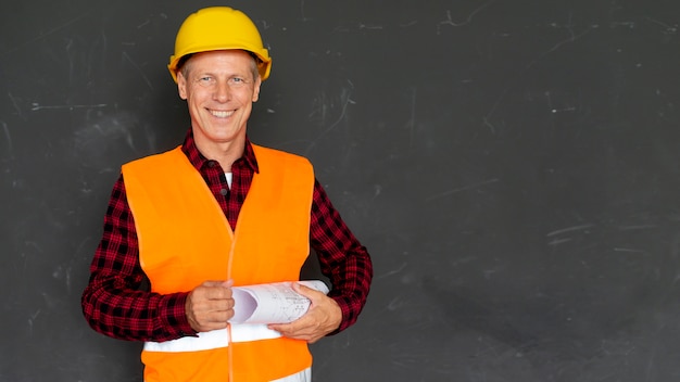 Smiley architect holding plans with copy space