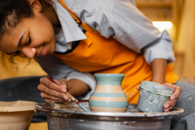 Smiley artist painting clay pot