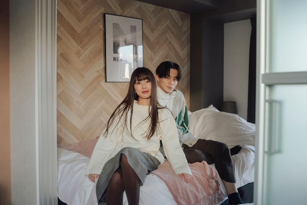 Улыбающаяся азиатская пара сидит в постели