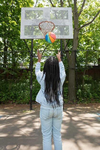 Smiley black teenage girl playing basketball