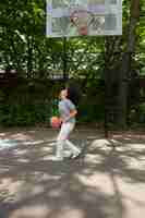 Free photo smiley black teenage girl playing basketball