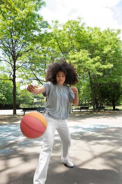 バスケットボールをしているスマイリー黒の10代の少女
