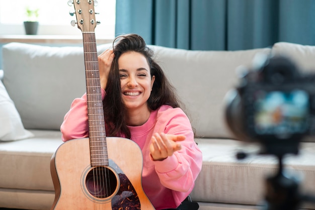 Free photo smiley blogger posing with her guitar