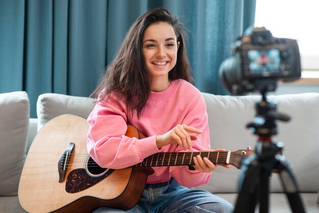 Smiley blogger recording herself with her guitar