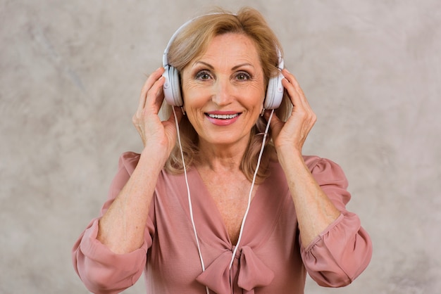 Smiley blonde lady listening to music on headphone set