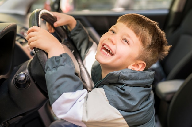 Free photo smiley boy in car