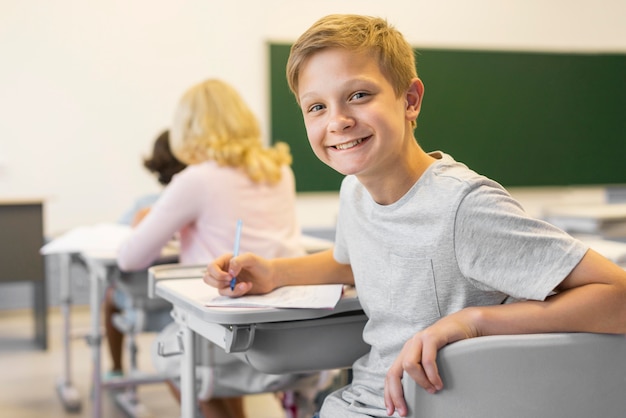 Free photo smiley boy in class