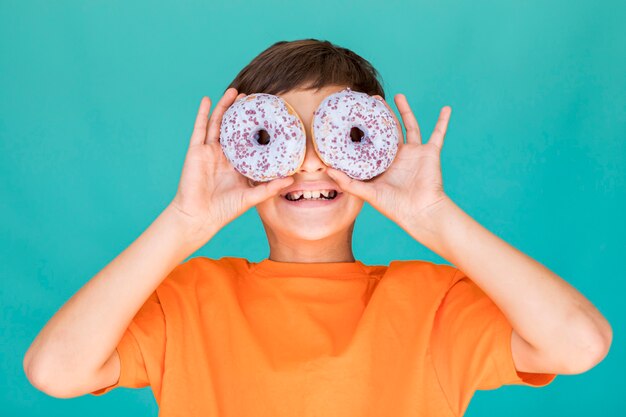 도넛으로 그의 눈을 덮고 웃는 소년
