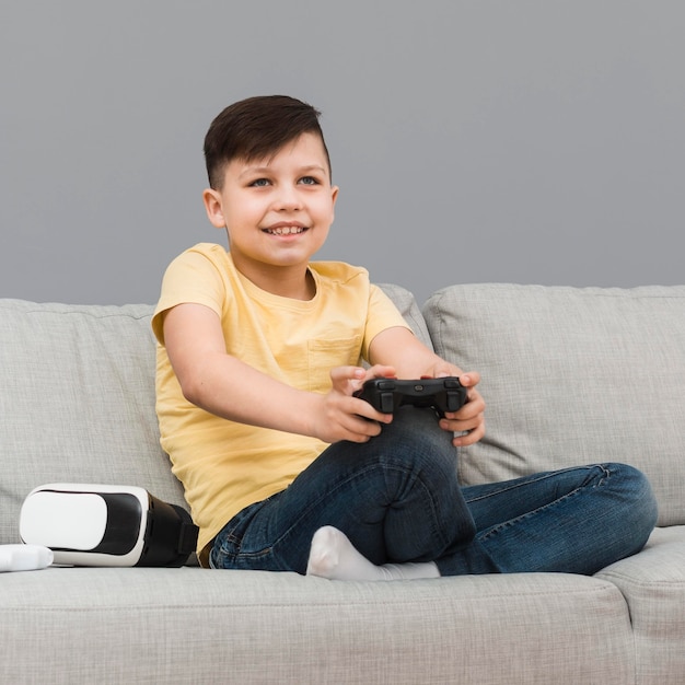 Улыбающийся мальчик играет в видеоигры