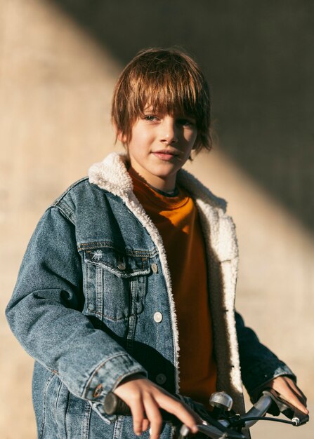 Smiley boy posing outdoors in the city while riding his bike