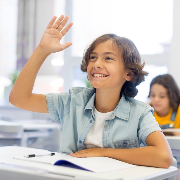 Smiley boy with hand raised