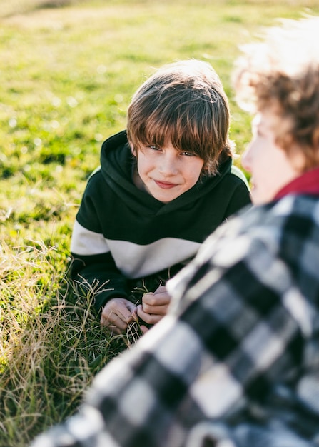 Free photo smiley boy with his friend on grass outdoors