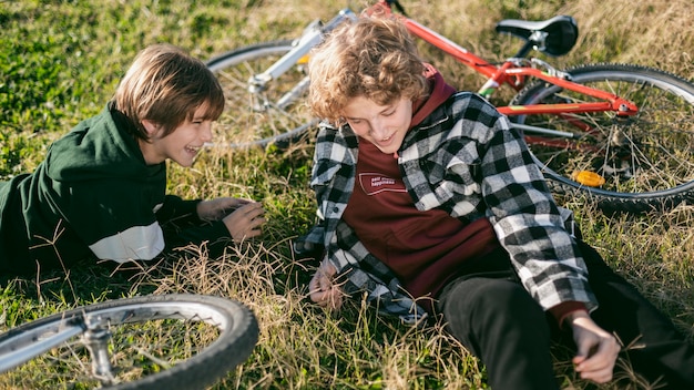 自転車に乗っている間草の上でリラックスしているスマイリーの男の子