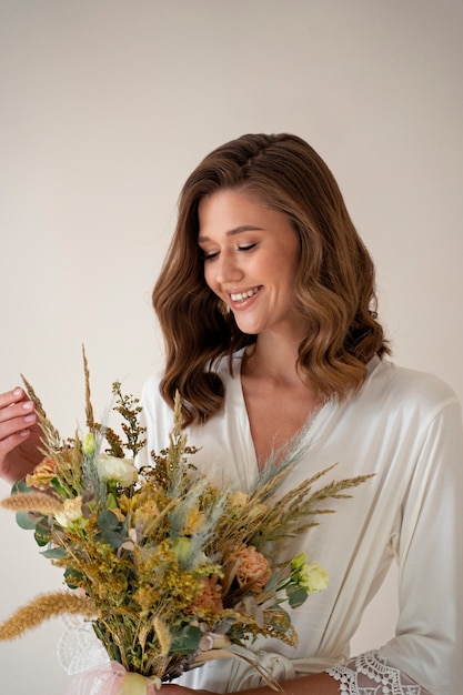 Smiley bride holding flowers side view