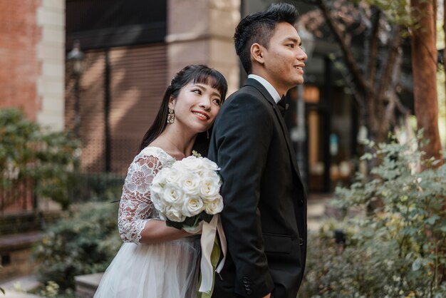 Smiley bride leaning against groom's back