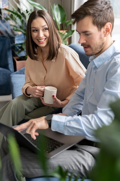 Smiley business man and woman working together in the office with laptop