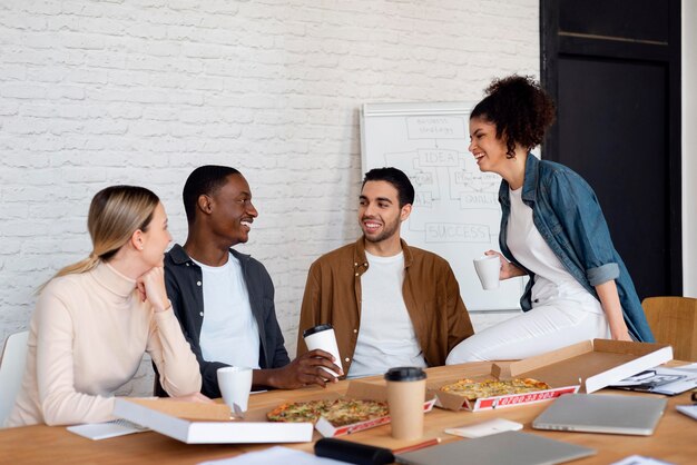 Smiley business people with pizza medium shot