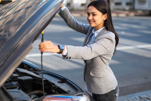 Free photo smiley businesswoman lifting the car's hood