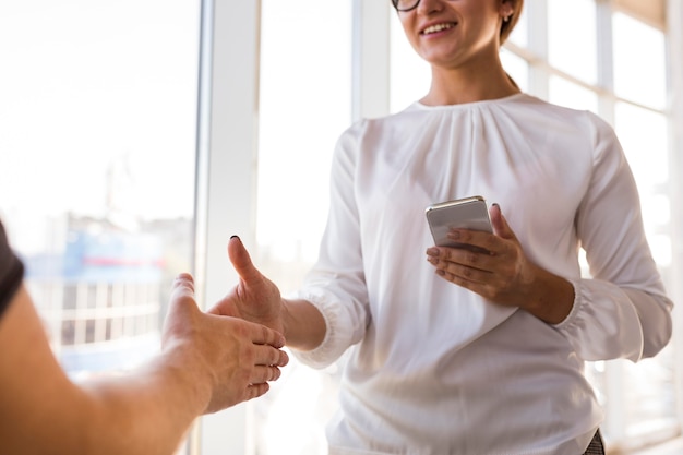 Smiley businesswoman saluting someone