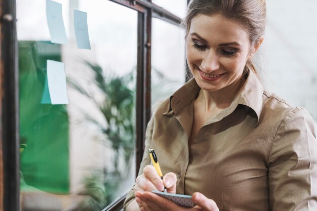 Smiley businesswoman taking notes during a meeting