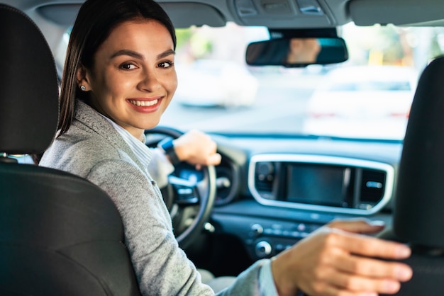 Smiley businesswoman turning around in the car