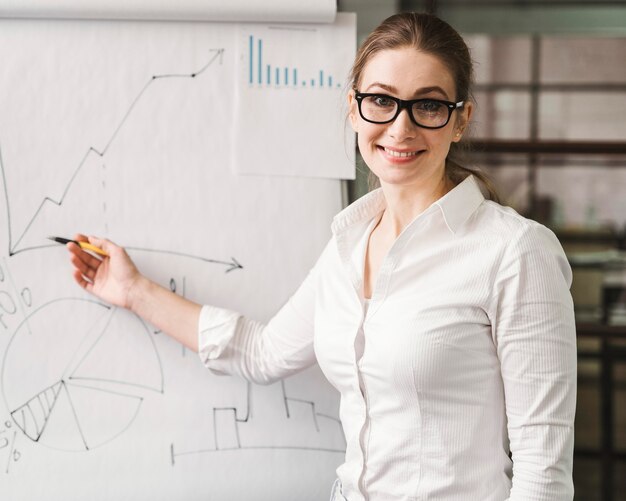 Smiley businesswoman with glasses giving a presentation
