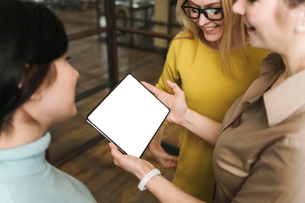 Free photo smiley businesswomen with tablet during a meeting