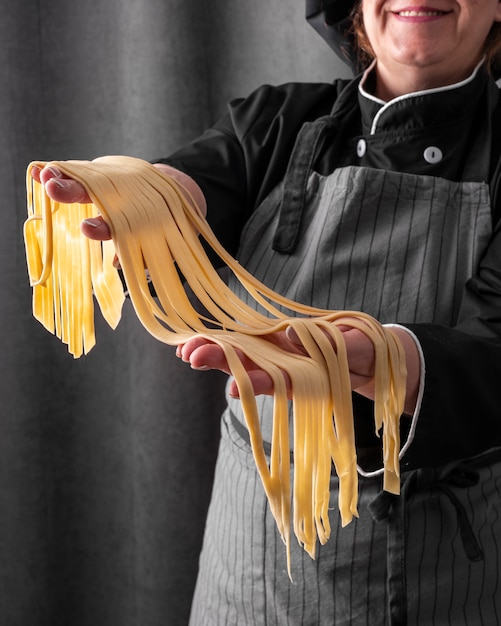 Smiley chef holding fresh pasta