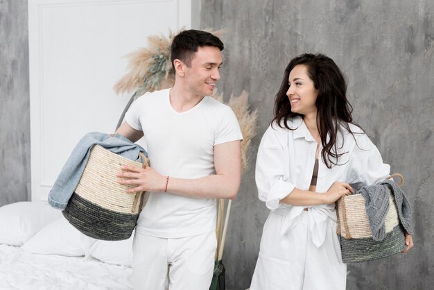 Smiley couple holding baskets together