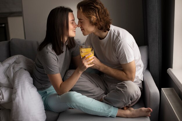 Улыбающаяся пара держит стакан апельсинового сока